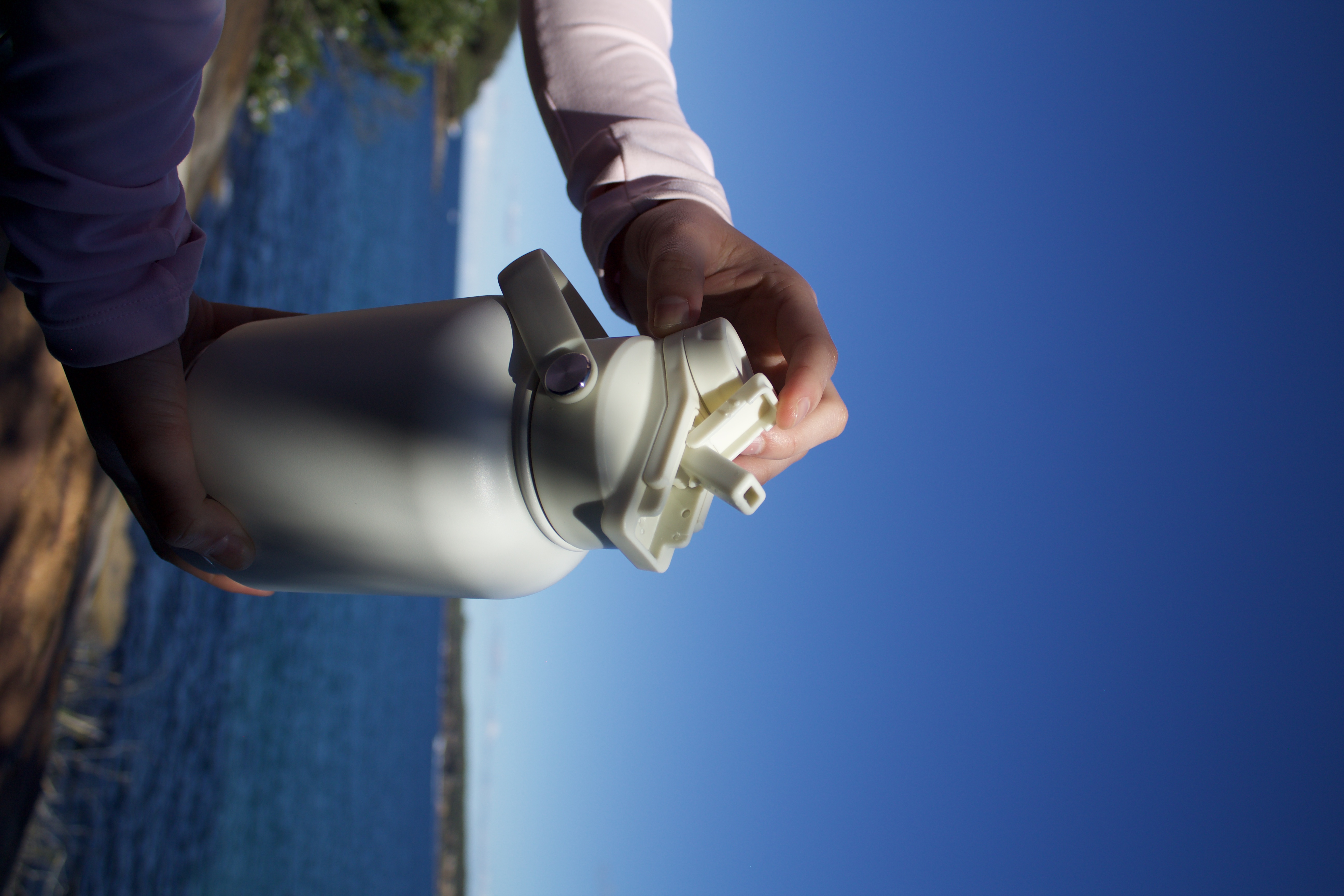 Owner and dog on a scenic trail walk carrying a premium flask